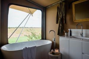 a bathroom with a tub and a sink and a window at Mitchell Grass Retreat in Longreach