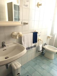 bagno bianco con lavandino e servizi igienici di Goccia Azzurra a Silvi Marina