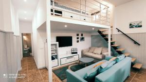 a living room with a blue couch and a loft bed at Villas Norte Piscina privada climatizada in La Victoria de Acentejo