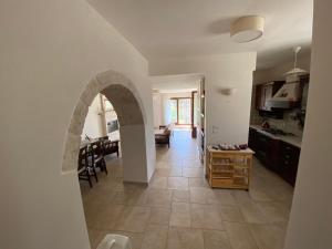 a kitchen and living room with an archway at Il Pepe Rosa - Valle D'Itria in Martina Franca