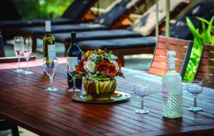 een tafel met wijnglazen en een vaas met bloemen bij Villa Anka in Zaton