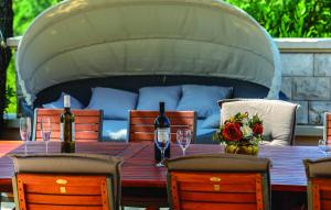 - une table en bois avec 2 bouteilles de vin et des chaises dans l'établissement Villa Anka, à Zaton