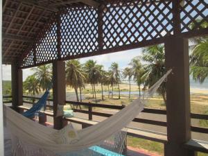 een hangmat in een paviljoen met uitzicht op het strand bij Natal Casa de Playa en Pitangui‏ in Pitangui