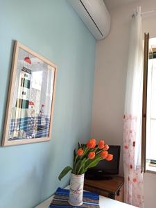 una stanza con tavolo e vaso di fiori d'arancio di Goccia Azzurra a Silvi Marina
