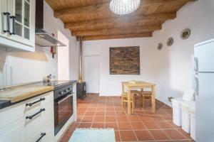 - une cuisine avec des plafonds en bois et une table dans une chambre dans l'établissement Casa do Pelourinho, à Aljezur