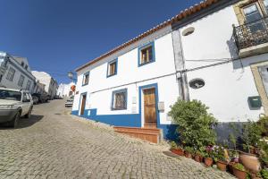 un bâtiment blanc et bleu sur le côté d'une rue dans l'établissement Casa do Pelourinho, à Aljezur