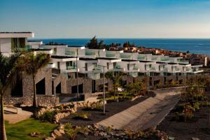 un grande edificio con l'oceano sullo sfondo di Luxury Villa - new building with panoramic sea view ad Adeje