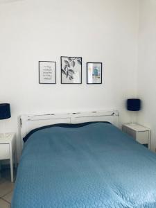 普利莫頓的住宿－Bila lucica，卧室配有一张蓝色的床,墙上挂有三张照片