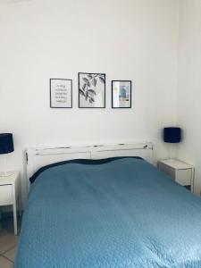 ein Schlafzimmer mit einem blauen Bett mit drei Bildern an der Wand in der Unterkunft Bila lucica in Primošten + 25 Fotos