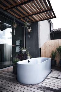 a white bath tub sitting on a wooden floor in a bathroom at Hotel Gerl in Salzburg