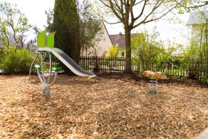 un parque infantil con un tobogán en un patio en Landgasthof Vogelsang OHG en Weichering