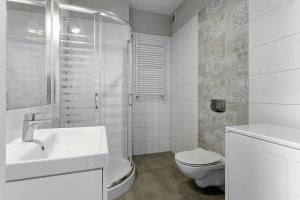 a white bathroom with a toilet and a sink at Apartament w centrum, zarezerwuj teraz in Lublin +13 photos