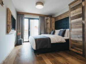ein Schlafzimmer mit einem großen Bett und einer Holzwand in der Unterkunft VAYA Ladis in Ladis