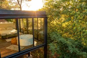 a glass house with a tub on a deck at Peso Village in Amarante