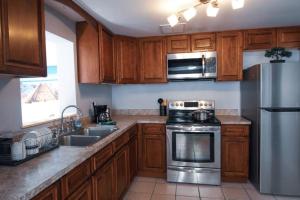 uma cozinha com armários de madeira e electrodomésticos de aço inoxidável em Spacious Family-sized Home in Central Location em Jacksonville