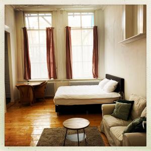 ein Wohnzimmer mit einem Bett und einem Sofa in der Unterkunft Cleen Rochelle in Middelburg