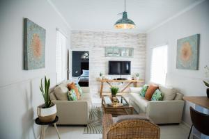 uma sala de estar com um sofá e uma televisão em Mahdi Cottage em Swakopmund