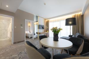 Una sala de estar con una mesa y sillas blancas. en Imperiall Resort & MediSpa, en Ustronie Morskie