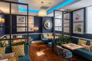 a restaurant with blue walls and couches and tables at Oakley Hall Hotel in Basingstoke