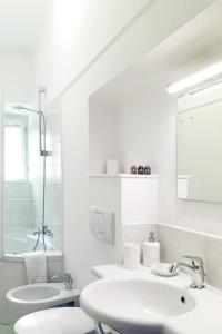 a white bathroom with two sinks and a mirror at Lovely Apt 3min Walk to Ponte Vecchio in Florence