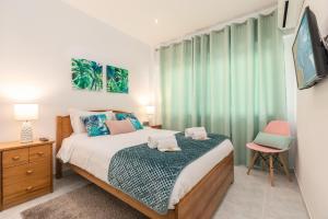 ポルティマンにあるAquazul Beach Flat - Praia da Rochaのベッドルーム(ベッド1台、緑のカーテン付)