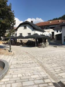 a patio with tables and umbrellas in front of a building at Luxury apartment in the heart of Jajce in Jajce