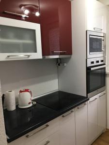 a kitchen with white cabinets and a black counter top at Luxury apartment in the heart of Jajce in Jajce