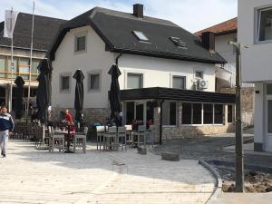 a building with people sitting at tables in front of it at Luxury apartment in the heart of Jajce in Jajce