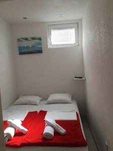1 dormitorio con 1 cama con manta roja y almohadas blancas en Luxury apartment in the heart of Jajce, en Jajce