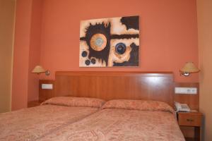 a bedroom with a bed and a painting on the wall at Hostal Quevedo in León