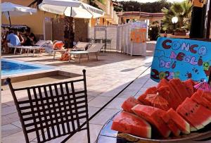 a plate of watermelon on a table next to a pool at Conca Degli Dei in Paestum