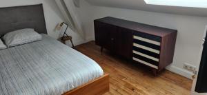 ビアリッツにあるLe Rooftop des Hallesのベッドルーム1室(ベッド1台、木製ドレッサー付)