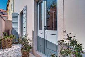 a door to a house with potted plants at Casa Santa Maria Vacation House in Mali Lošinj