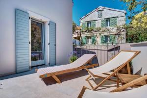 une terrasse avec 2 chaises et une maison dans l'établissement Casa Santa Maria Vacation House, à Mali Lošinj