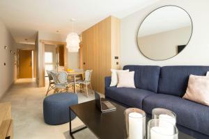 a living room with a blue couch and a table at Goodnight Cádiz Apartments in Cádiz