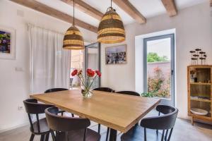 a dining room with a wooden table and chairs at Casa Santa Maria Vacation House in Mali Lošinj