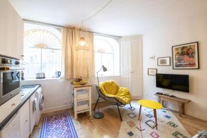ein Wohnzimmer mit einem Tisch, einem Schreibtisch und einem TV in der Unterkunft Le Studio Gab's - Coup de coeur déco tout confort in Caluire-et-Cuire