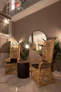 two wicker chairs and a mirror in a room at Goodnight Cádiz Apartments in Cádiz