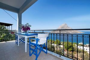 カリムノスにあるEirinis house with amazing view in Masouri Kalymnosの海を望むバルコニー(青いテーブル、椅子付)