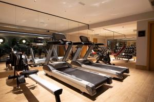a gym with a row of treadmills and machines at Goodnight Cádiz Apartments in Cádiz