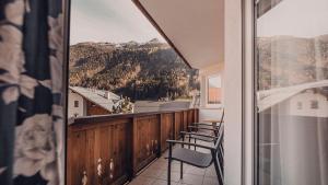 a balcony with chairs and a view of a mountain at Hotel Föhre in Ischgl