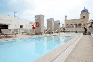 a swimming pool on the roof of a building at Goodnight Cádiz Apartments in Cádiz