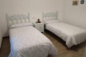 2 camas con sábanas blancas en una habitación en Vivienda rural Mogón-Junto al Guadalquivir B en Villacarrillo