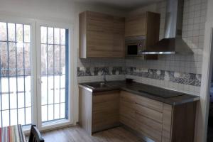 a kitchen with wooden cabinets and a sink and a window at Vivienda rural Mogón-Junto al Guadalquivir B in Villacarrillo