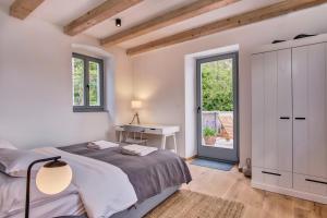 a bedroom with a bed and a desk and a window at Casa Santa Maria Vacation House in Mali Lošinj