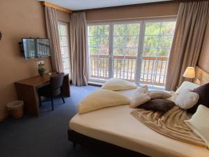 a bedroom with a bed and a desk and windows at Apart Vivaldi in See