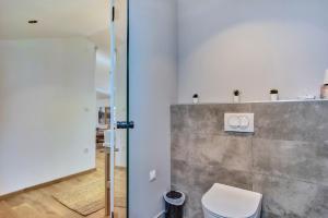 a bathroom with a toilet and a wall at Casa Santa Maria Vacation House in Mali Lošinj