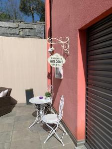 einen Tisch und zwei Stühle neben einem Gebäude in der Unterkunft MT's Cosy Place in Dino