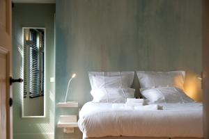 a bedroom with a bed with white pillows and a window at oYo in Kortrijk