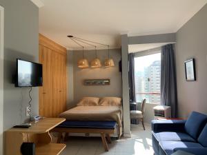 サンパウロにあるStudio A 50 mts do Hosp Sirio Libanesのベッドルーム(ベッド1台、テレビ、ソファ付)